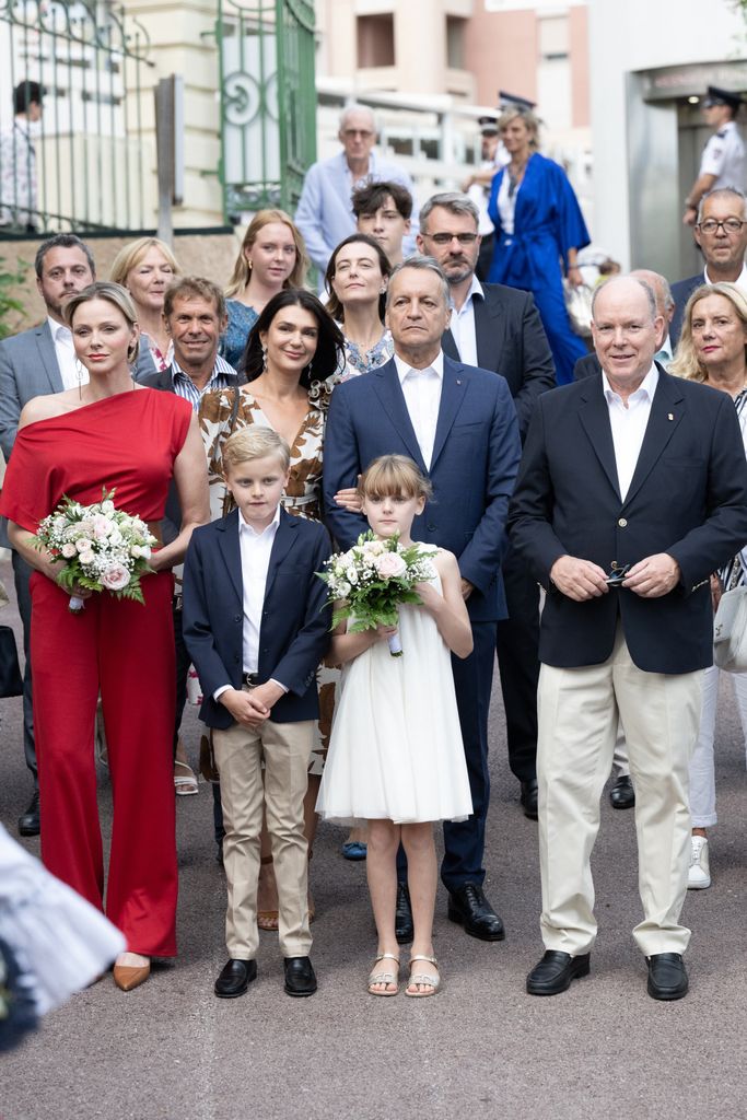 Princess Charlene in a red jumpsuit with family