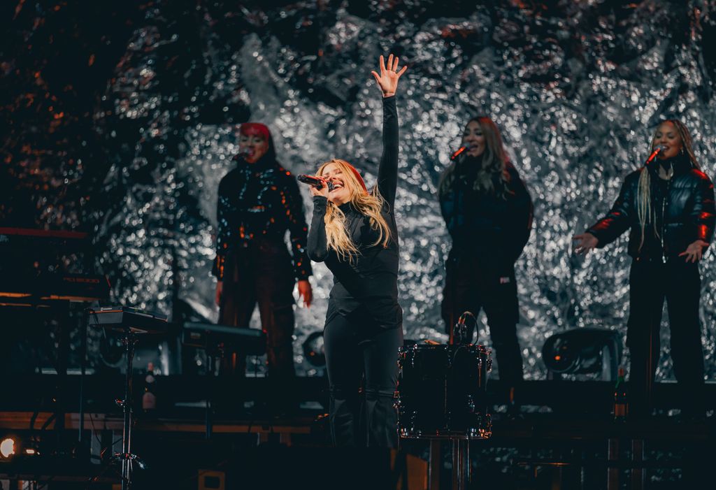 singer performing on stage in black outfit