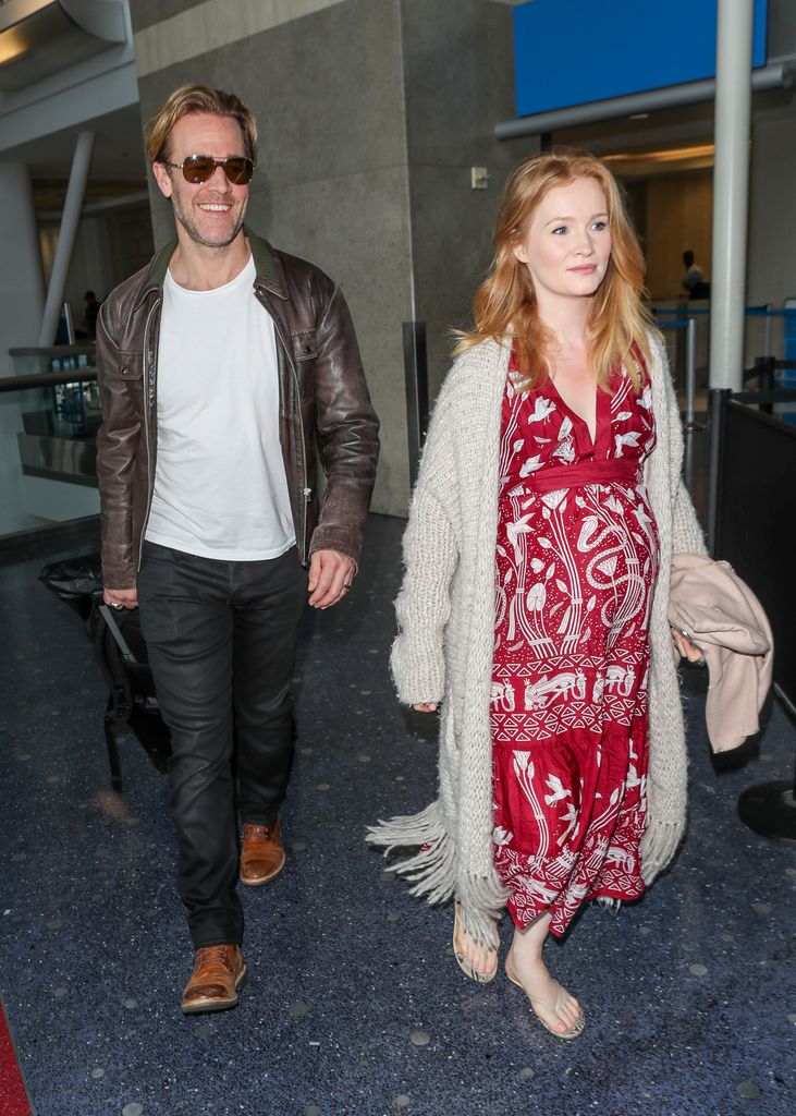James Van Der Beek in brown jacket and his wife Kimberly in red dress walking in 2018