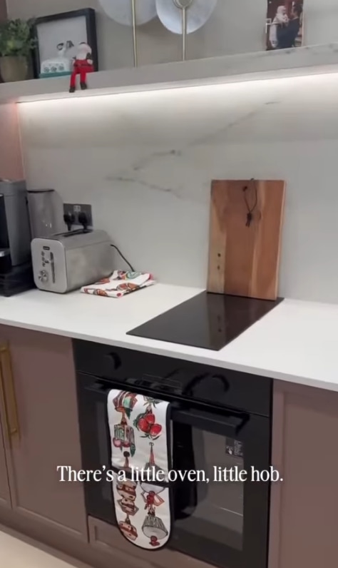shot of oven and hob with chopping board, toaster and coffee machine in background