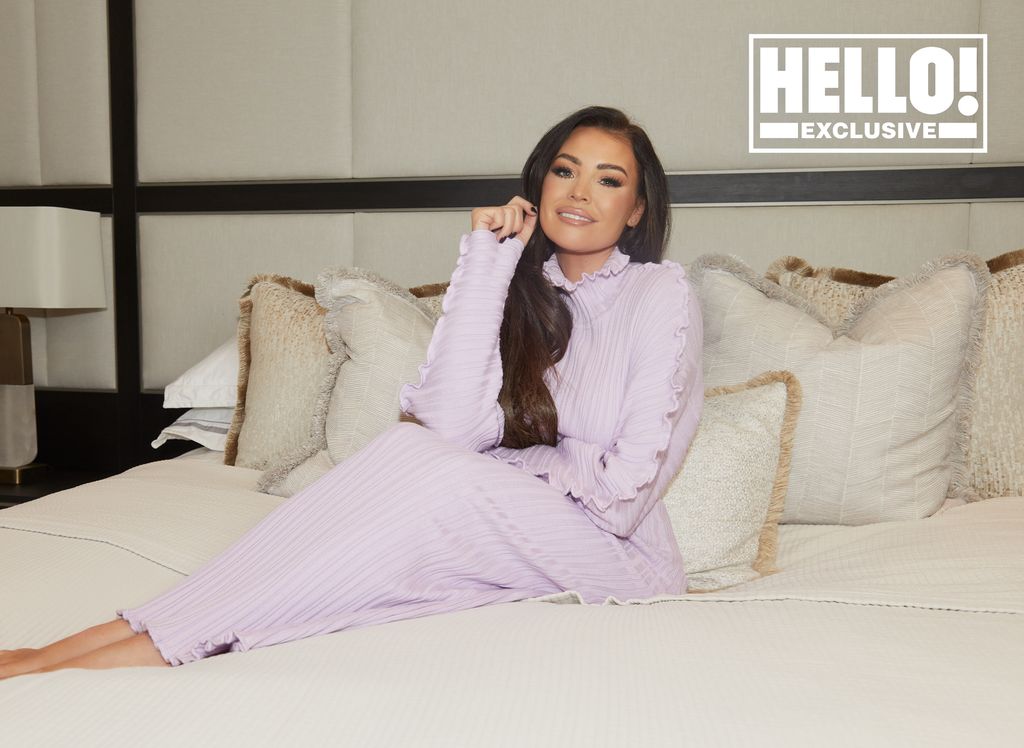 Jessica Wright wearing lilac dress posing on new bed in modern bedroom