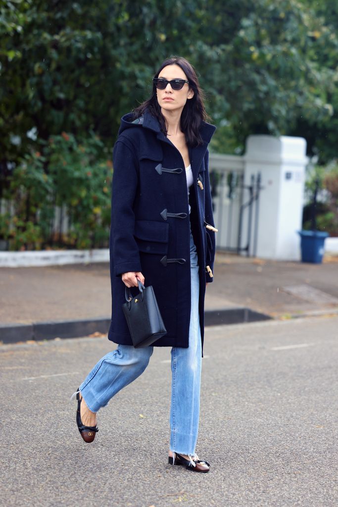 alexa chung wears blue jeans and a navy duffle coat while out in East London