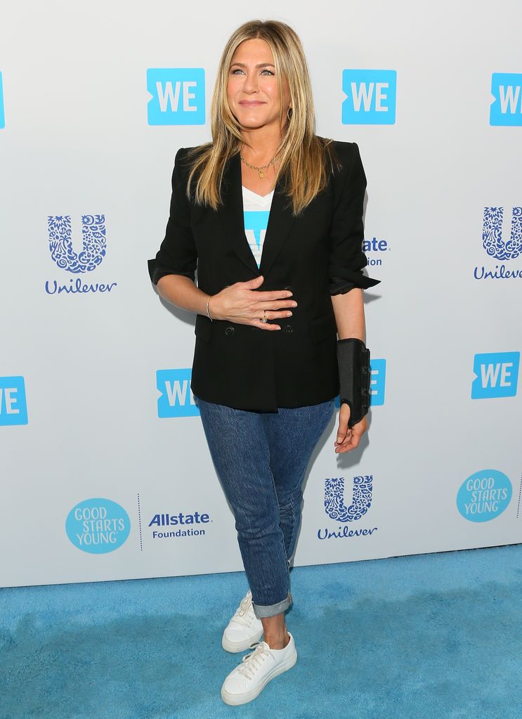 Jennifer Aniston on blue carpet in blazer and jeans