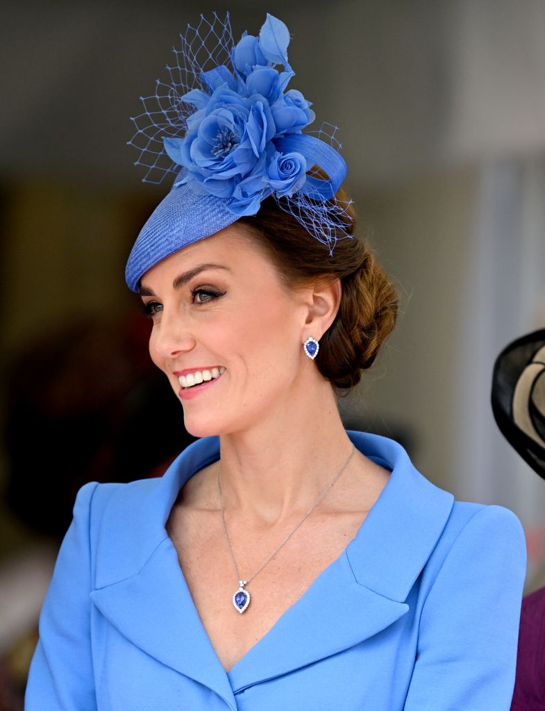 Kate Middleton smiling in blue hat and dress