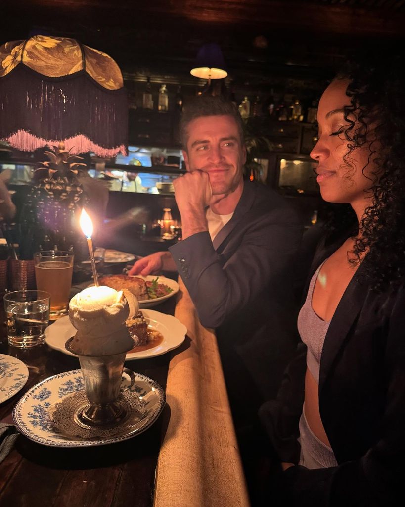 jake lockett staring at girlfriend with birthday cake on the table