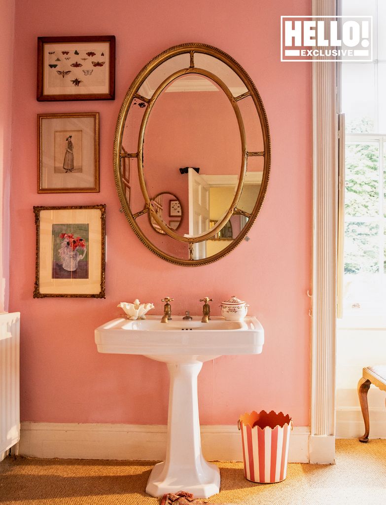 Conran family bathroom with pink paint and oval mirror over washbasin