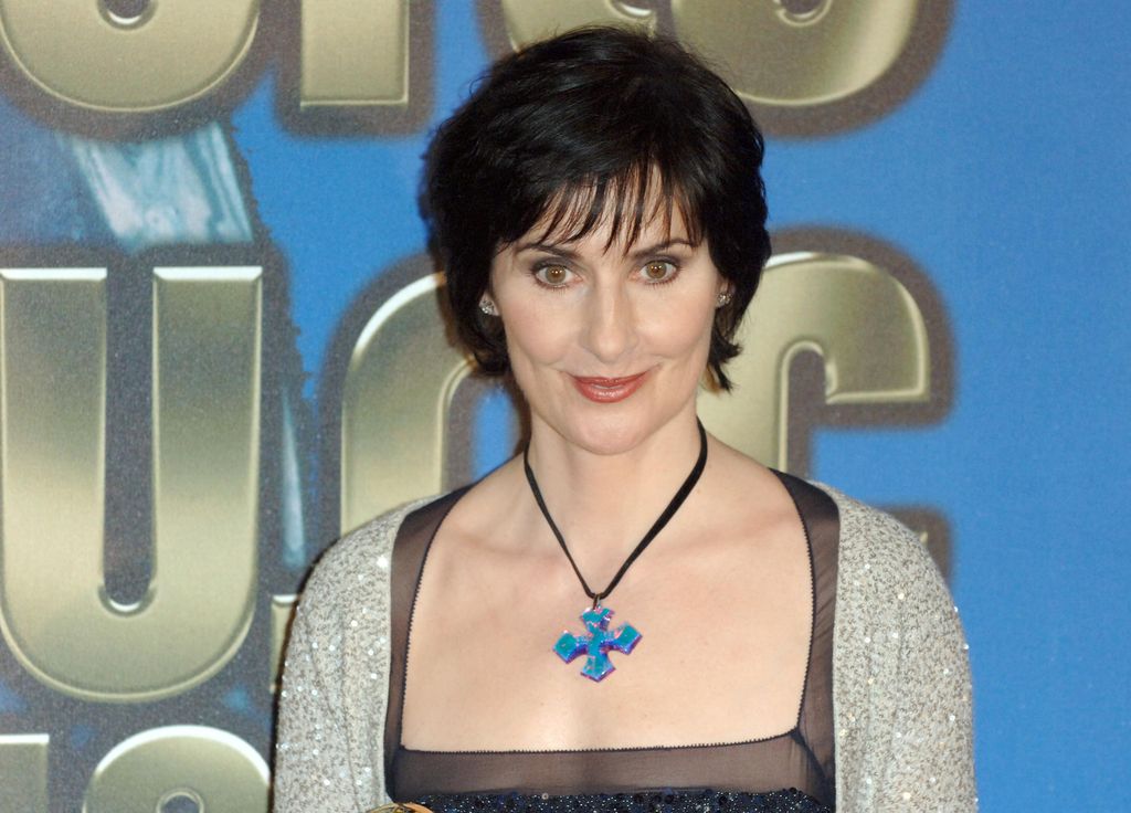 woman with dark short hair with blue cross necklace