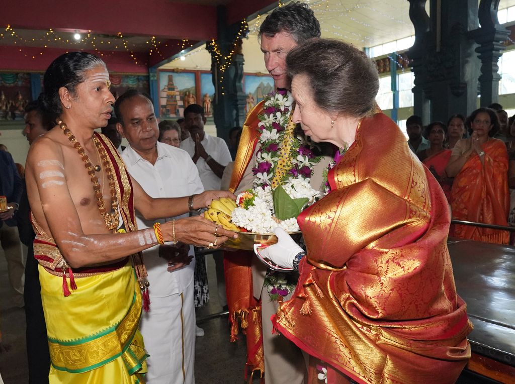 The Princess Royal and her husband Vice Admiral Sir Timothy Laurence prepare to make an offering during a visit to Vajira Pillayar Kovil Hindu temple in Colombo