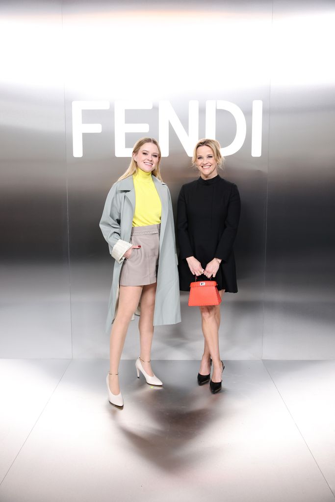 Ava and Reese in front of Fendi logo