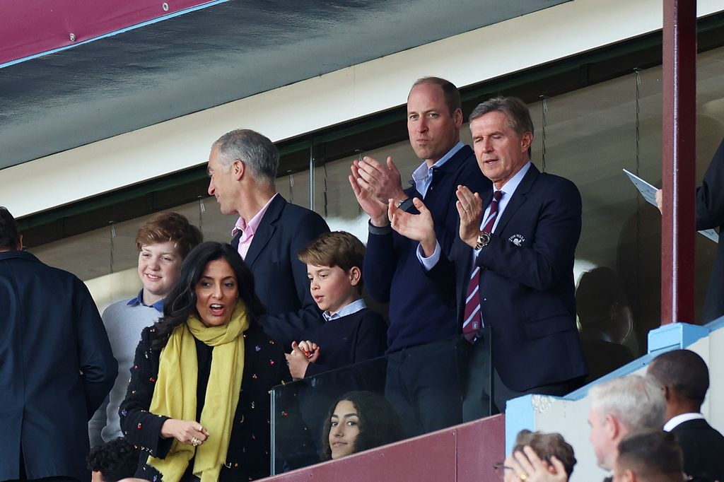 Prince George and Prince William at a football match