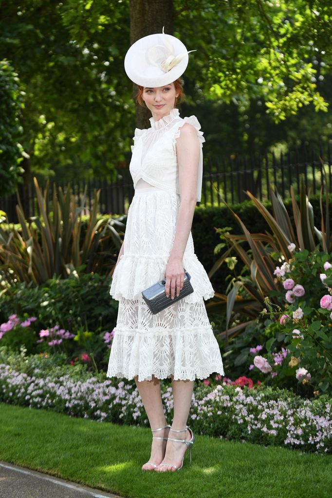Eleanor Tomlinson in a white lace ruffled dress and circular hat at Royal Ascot.