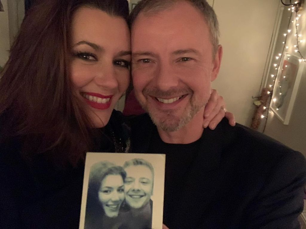 John Simm and his wife Kate holding up an old polaroid of themselves