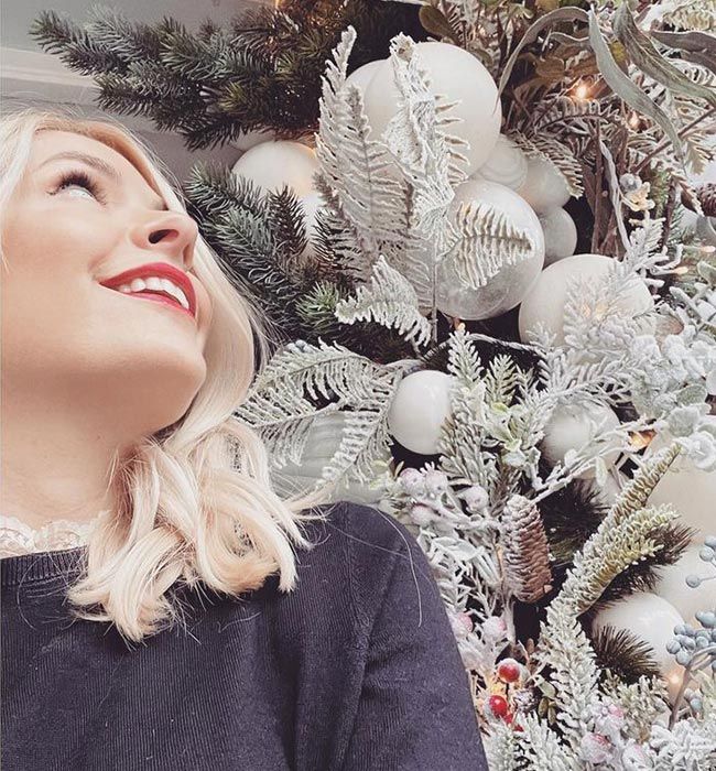 holly willoughby in red lipstick looking at christmas garland