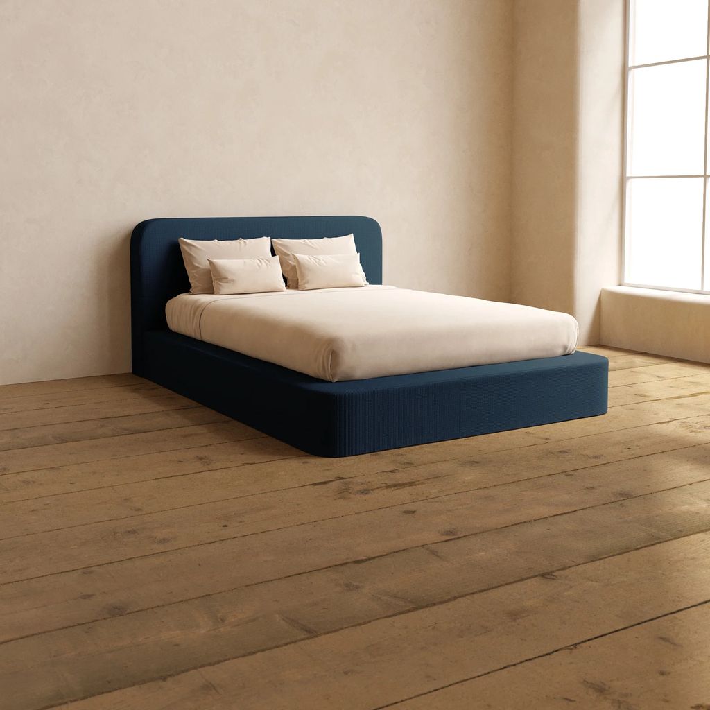 big blue bed on a wooden floor 