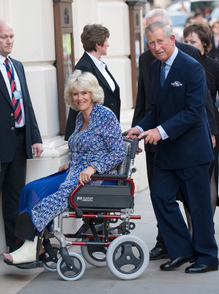 Queen Camilla in a wheelchair as she and King Charles arrive for the Premiere of Aida at the Royal Opera House
