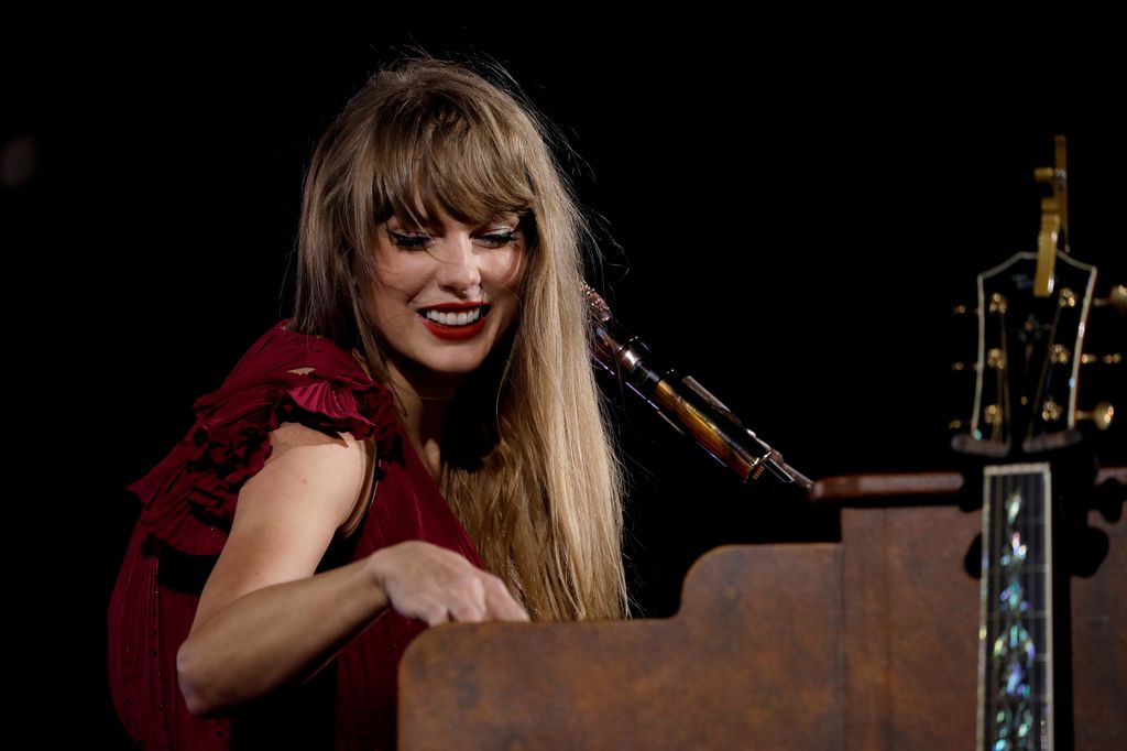 Taylor Swift performing on stage at piano