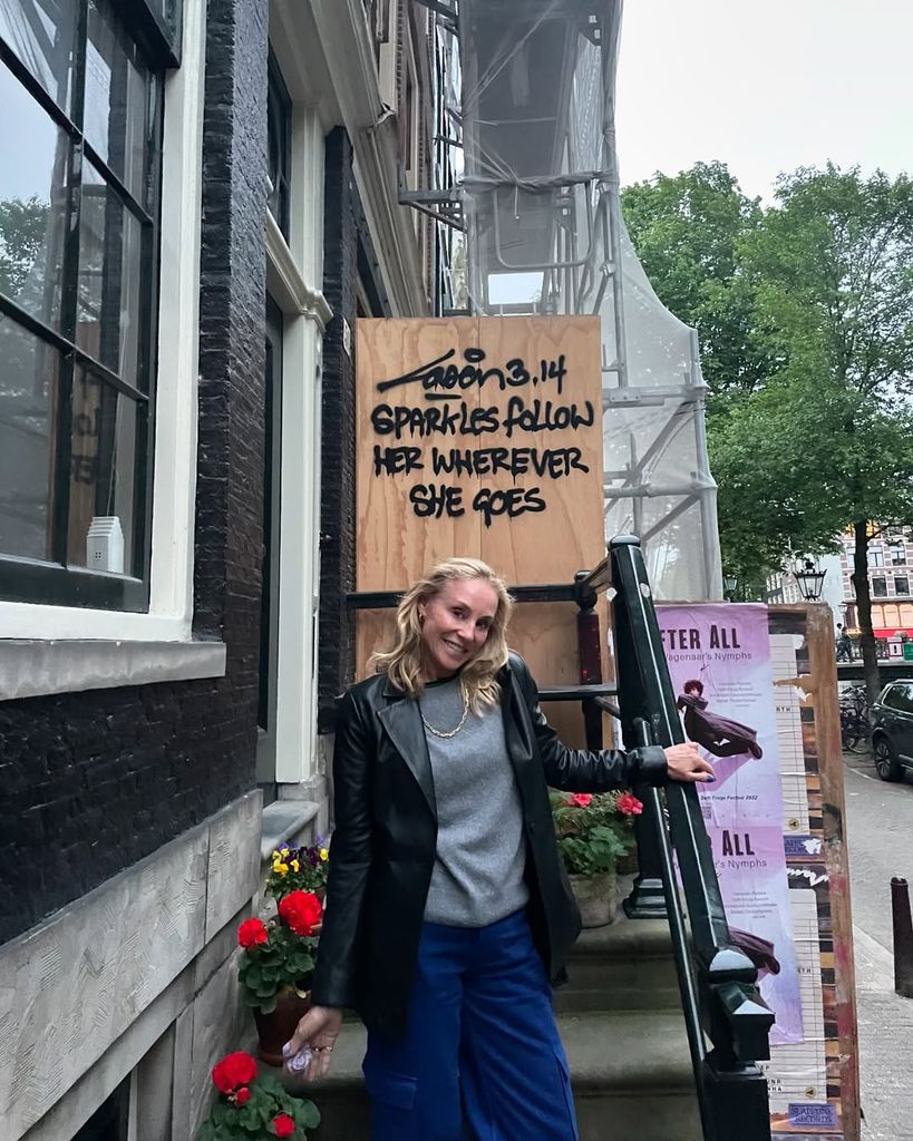 Tracy Pollan poses below a wooden sign beside a New York City street, shared on Instagram by Michael J. Fox