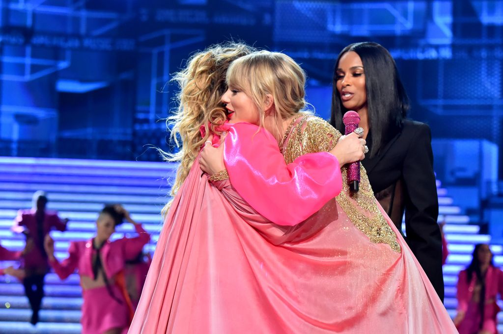 Shania Twain and Taylor Swift hugging on stage at the AMAs in 2019