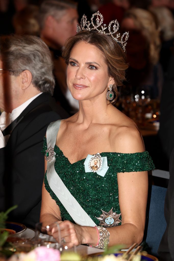 Princess Madeleine sitting in emerald dress and tiara