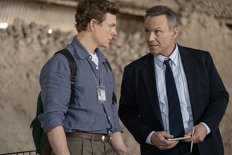younger man and older man in suit standing outdoors