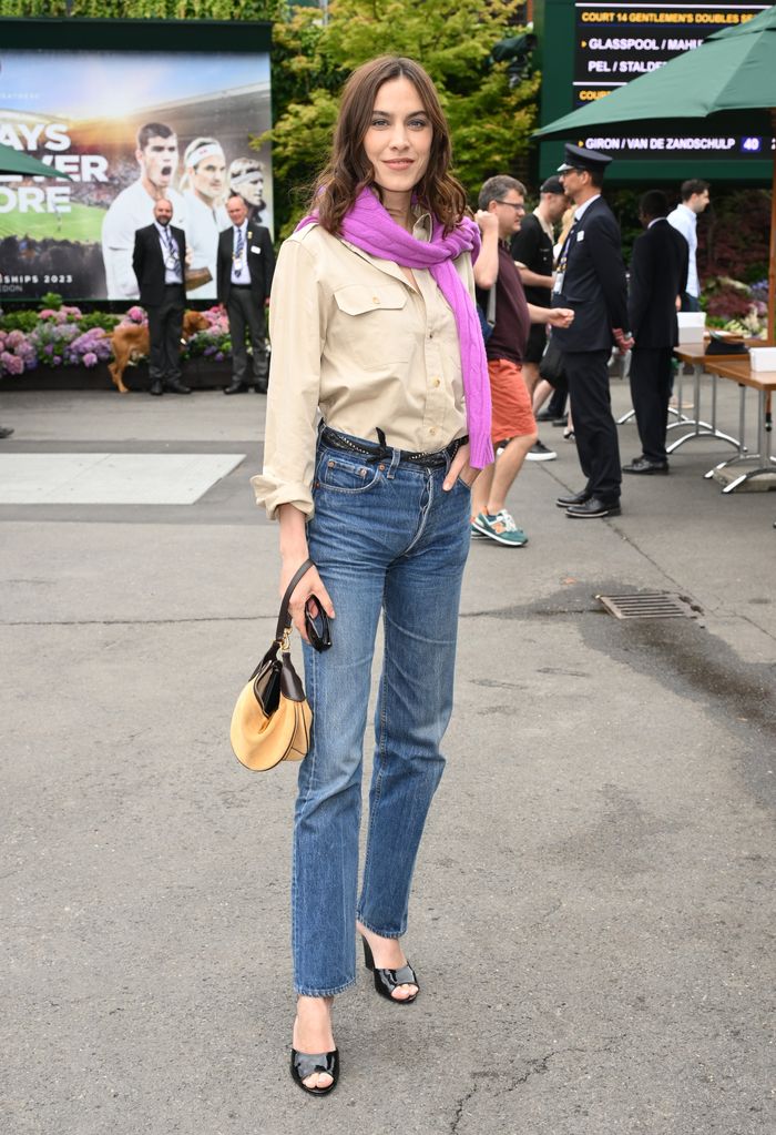 Alexa Chung wearing a beige shirt, straight-leg jeans and glossy mules 