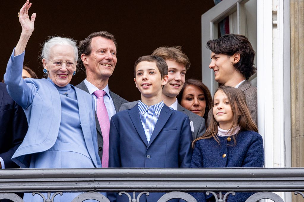 Queen Margarethe waving next to Count Henrik and Countess Athena; behind them are Prince Joachim, Count Felix and Count Nikolai