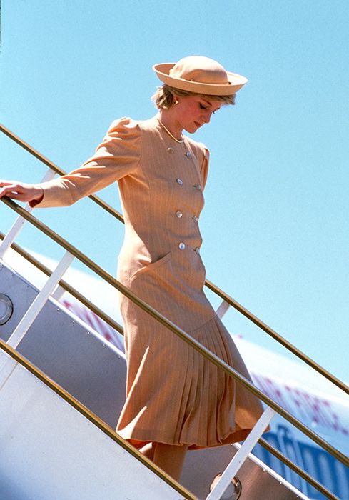 Princess Diana wearing a beige coat dress and matching hat, arrives at Melbourne Airport on October 27, 1985
