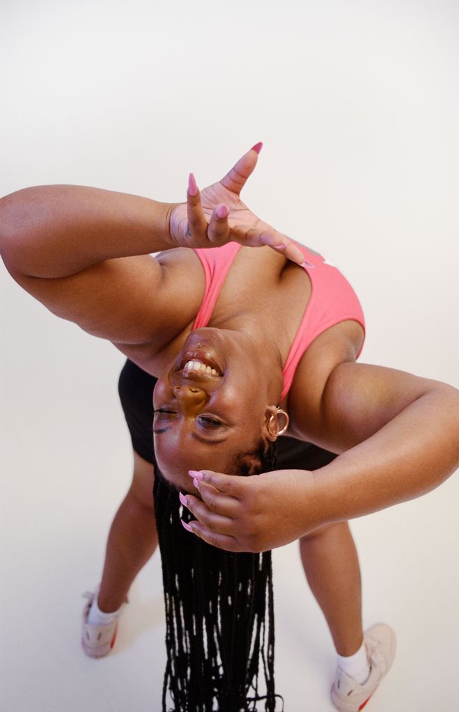 Black woman bending over backwards in a pink top