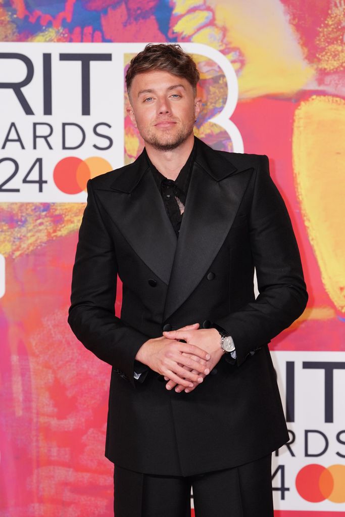 A close-up photo of Roman Kemp on the red carpet at the Brit Wards 2024 wearing a black suit