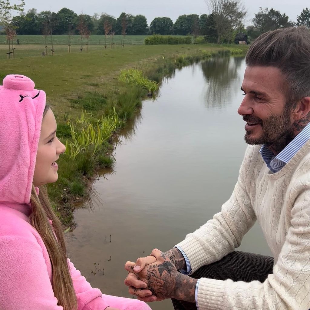 Harper Beckham wearing pink M&S Percy Pig onesie with dad David Beckham
