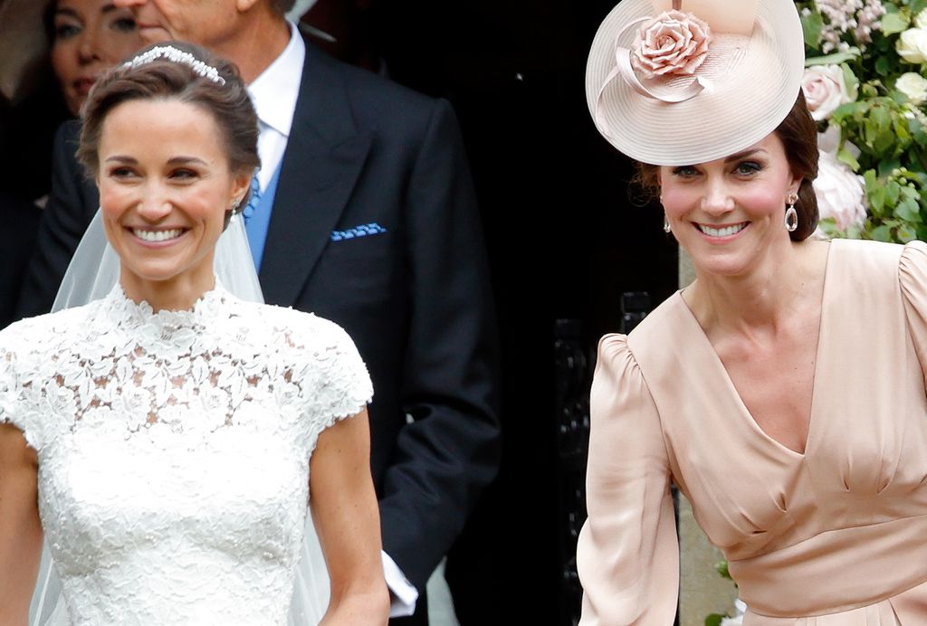 Pippa Middleton smiling next to bridesmaid Princess Kate in a pink dress