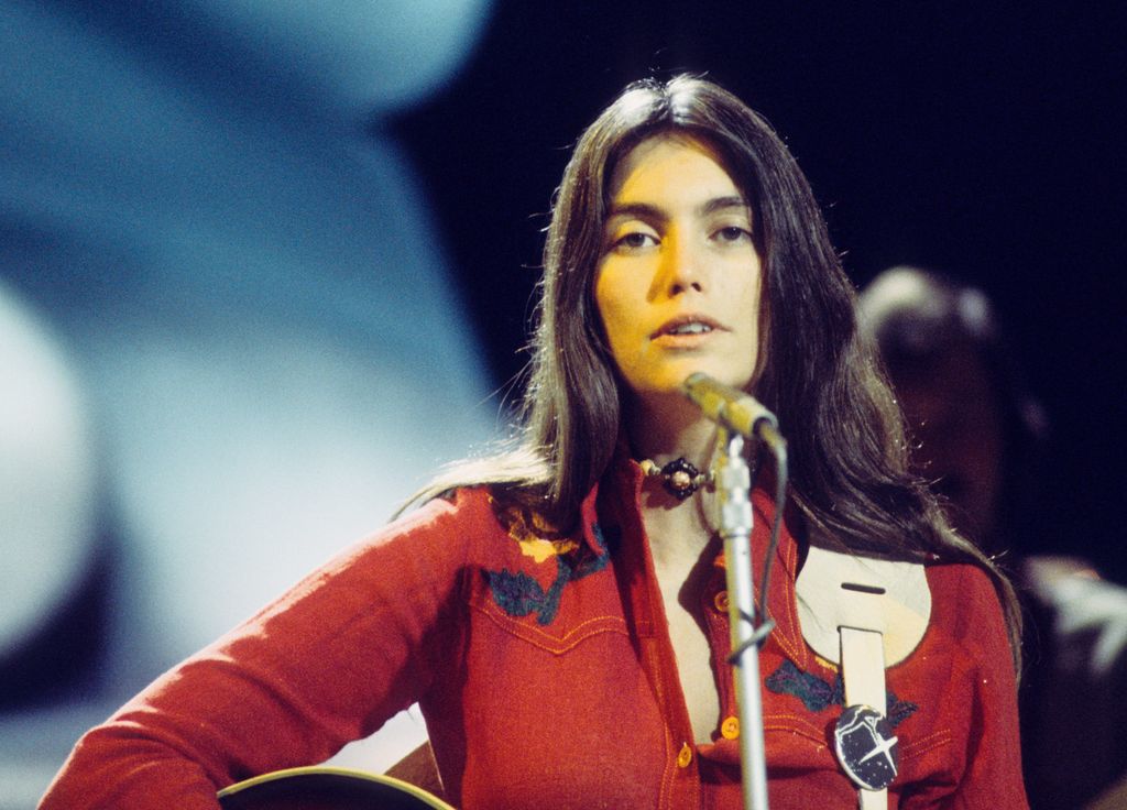 Emmylou Harris performs on a TV show wearing a red jacket