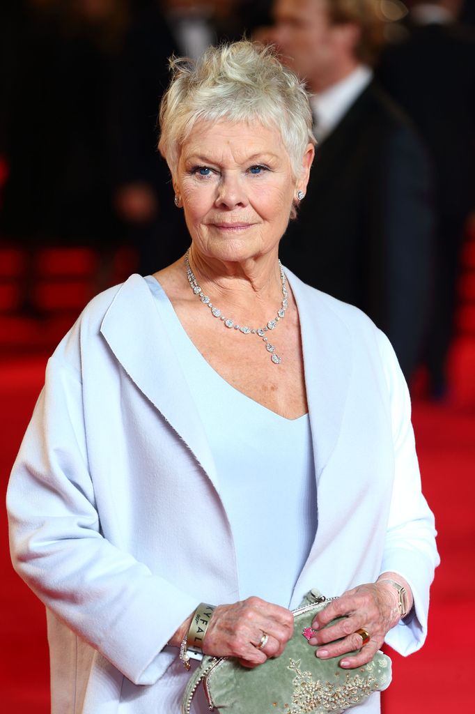 judi dench with a green clutch bag