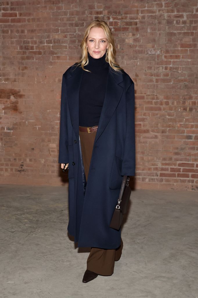 Uma Thurman in brown trousers and navy jumper and coat