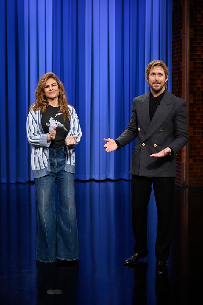Eva Mendes en jean et cardigan et l'acteur Ryan Gosling en blazer gris sur scène