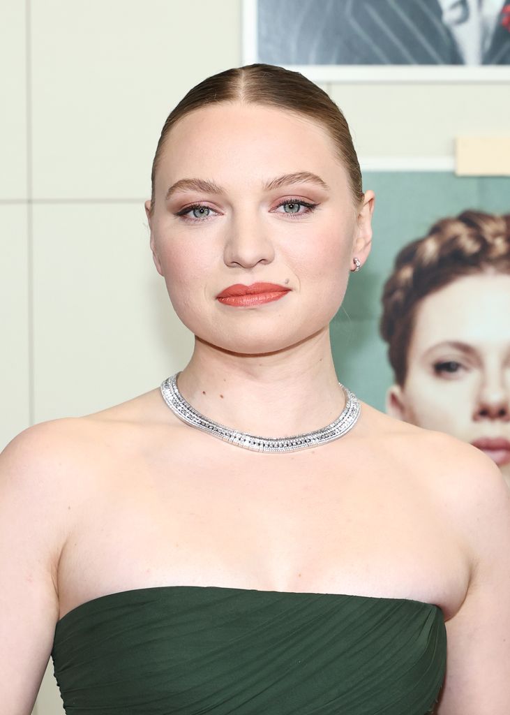 Close-up of Mia Threapleton’s soft glam beauty look featuring peachy lipstick and diamond-studded Boucheron necklace, worn to the New York premiere of The Phoenician Scheme.