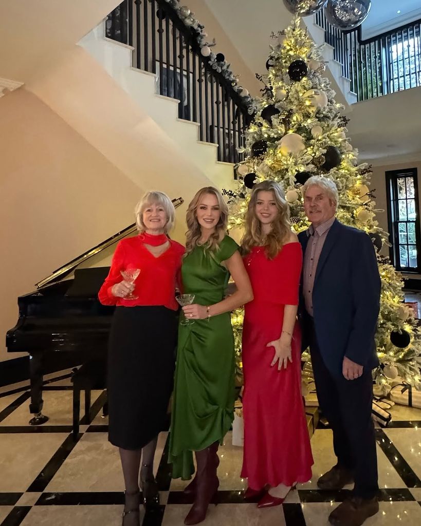 Amanda Holden and her daughter and parents standing the hallway of her home at Christmas