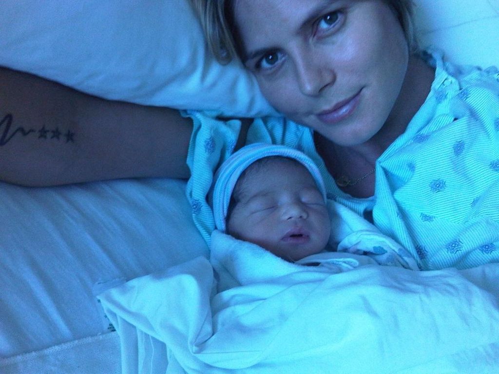 Heidi Klum laying in bed with baby daughter