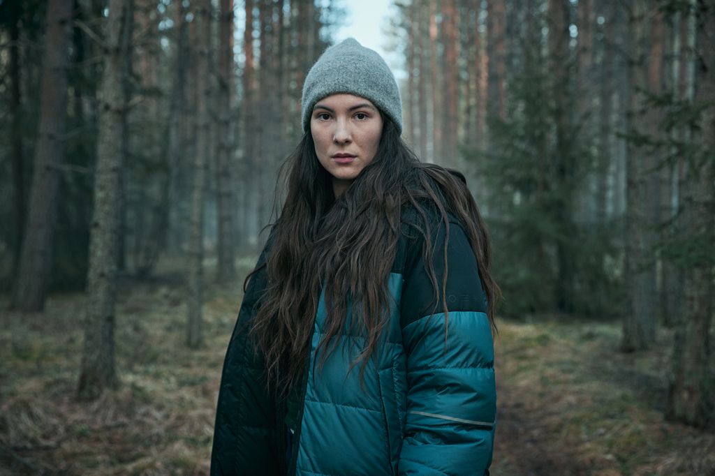 woman standing in woodland looking at camera