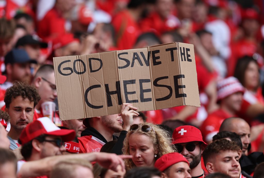 A cardboard sign reading 'God Save The Cheese'