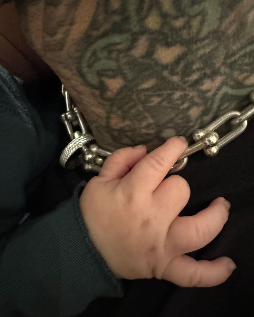 Baby Rocky clings onto his dad's chain