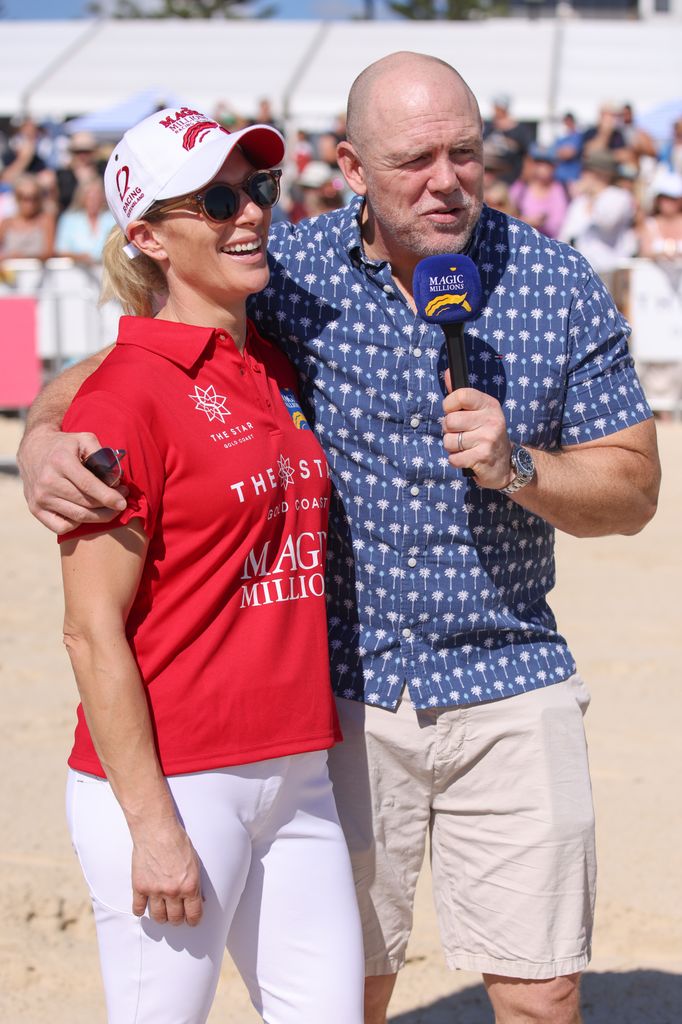 Zara Tindall in white trousers and a red top with husband Mike on the beach