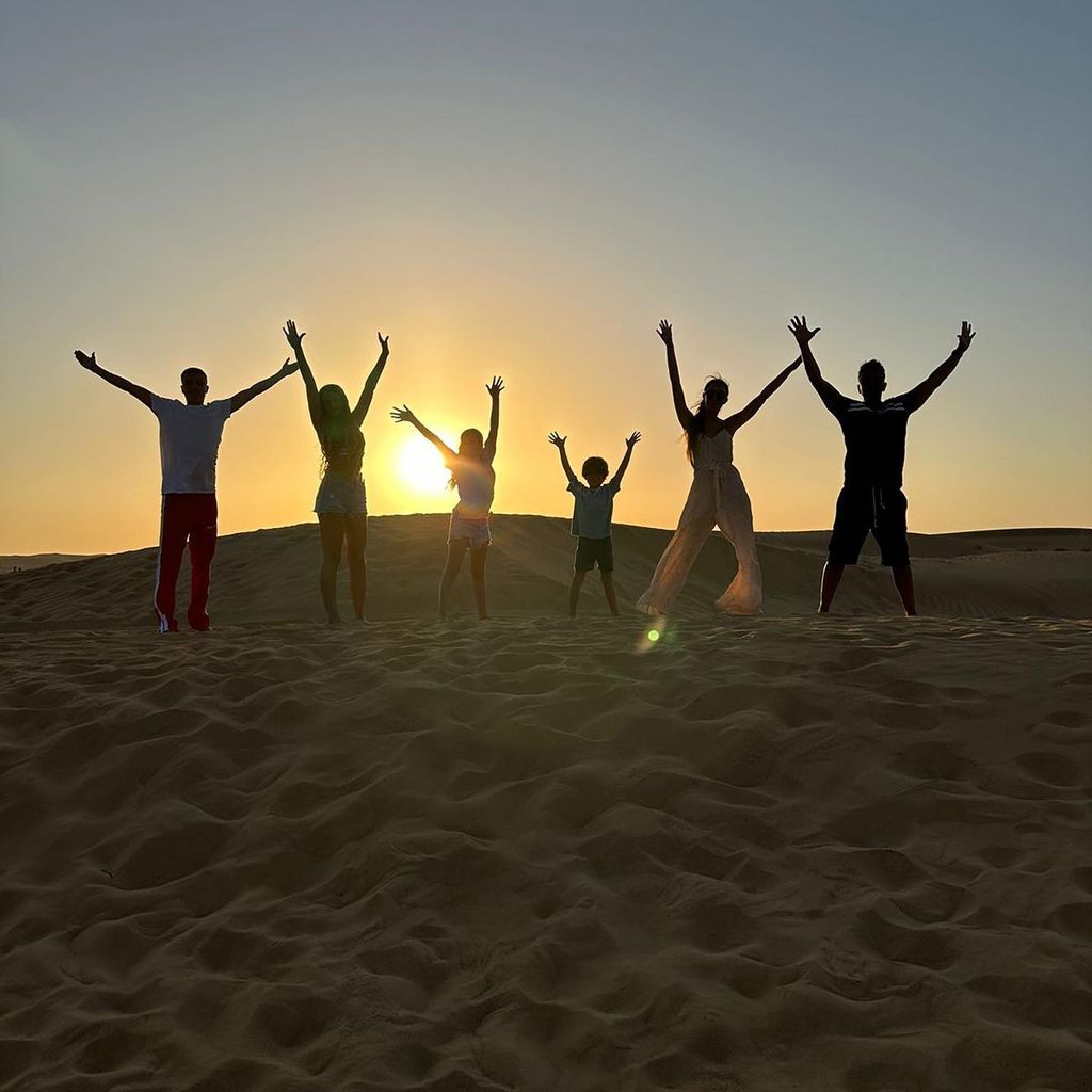 The Andre family jumping on a sand dune in Dubai 