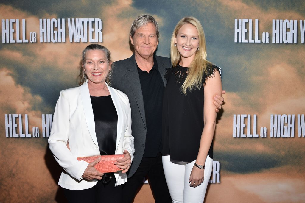 Susan Geston Bridges, Jeff Bridges and Isabelle Bridges stood together with their arms around each other smiling
