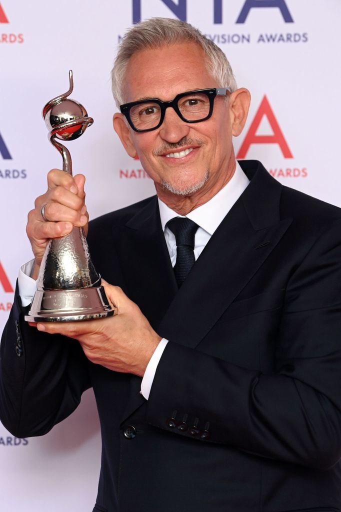 Gary Lineker in suit holding a trophy