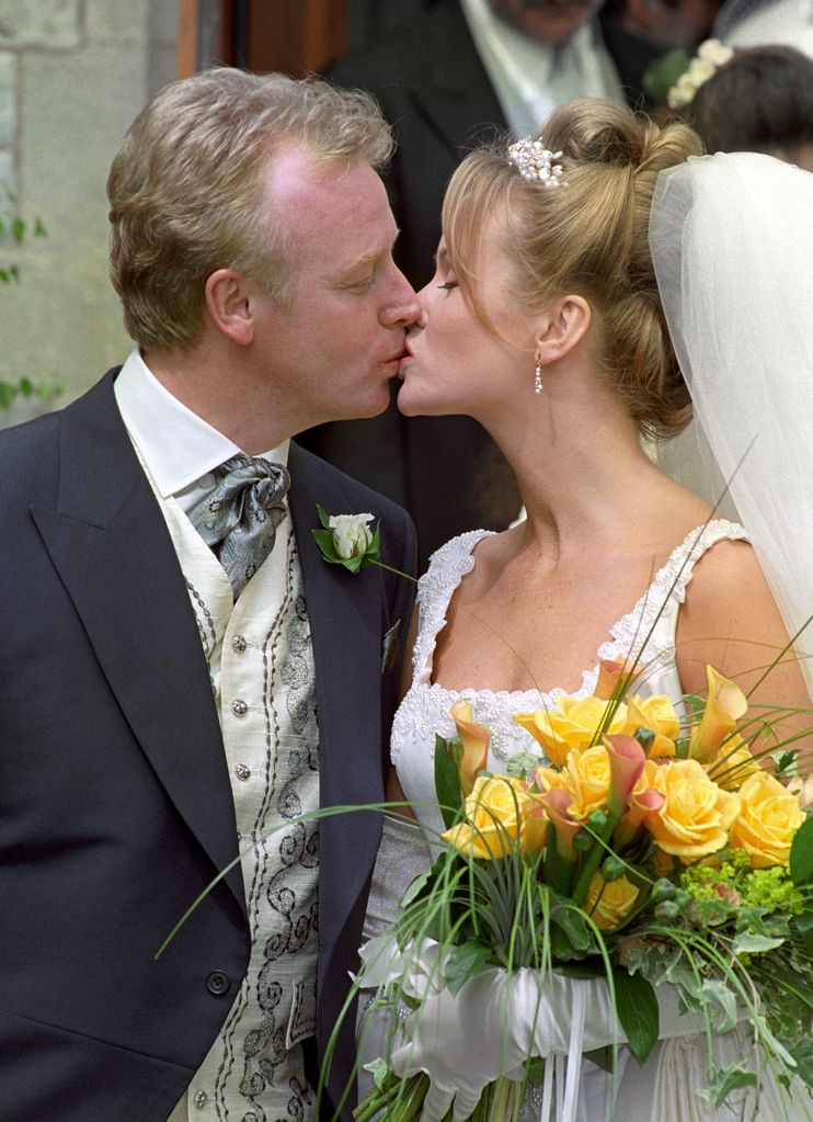 Amanda Holden and Les Dennis kissing on their wedding day