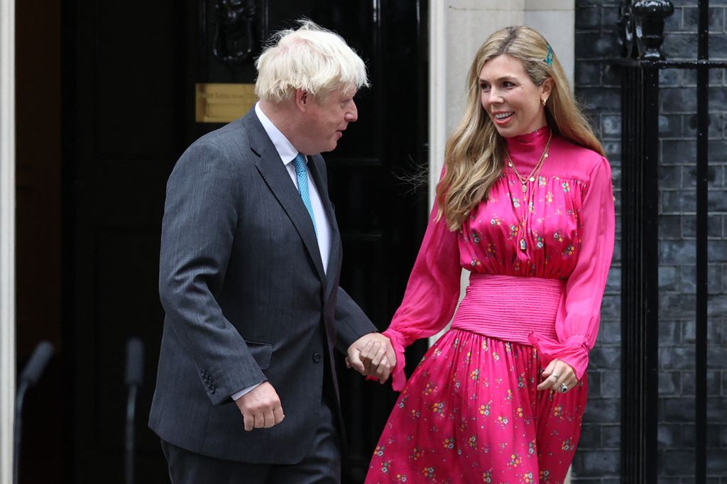 Britain's outgoing Prime Minister Boris Johnson (L) and his wife Carrie come out of Number 10 as Johnson prepares to deliver his final speech outside 10 Downing Street in central London on September 6, 2022, 