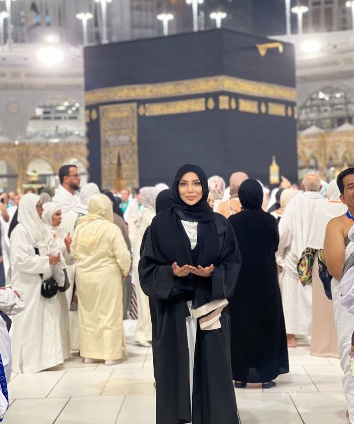 Farah El Kadhi in a black hijab in front of Mecca