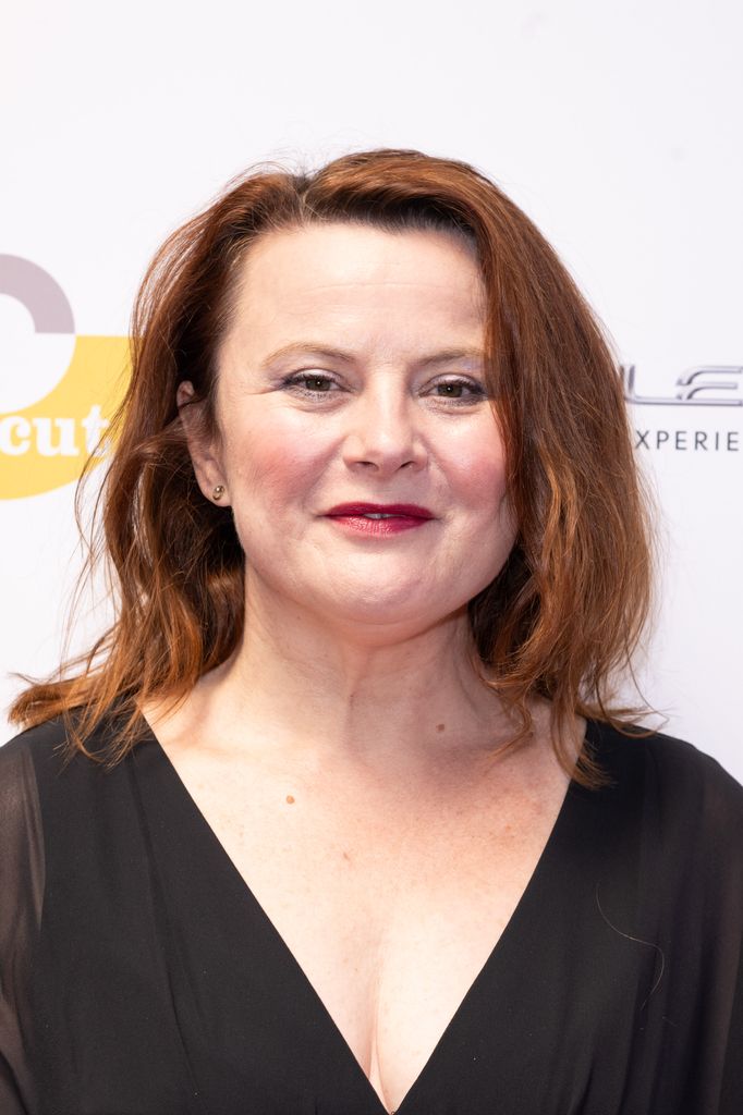 Monica Dolan in a black dress