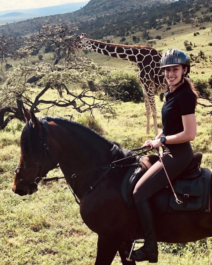 Tatiana Mountbatten on a horse near a giraffe